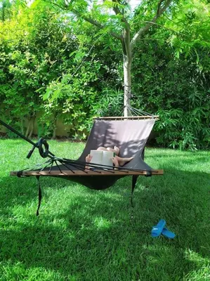 a hammock in the grass with a teddy bear sitting in it at Garden house by the sea in Vari