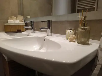 a white sink in a bathroom with a mirror at Garden house by the sea in Vari