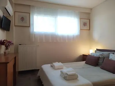a bedroom with two towels on a bed with a window at Garden house by the sea in Vari