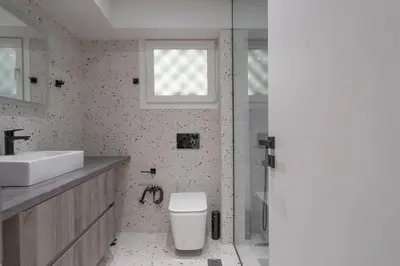 a bathroom with a toilet and a sink and a window at Voula's 2BR Escape Elegant and Stylish Living in Athens