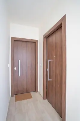 two wooden doors in a room with a hallway at Voula's 2BR Escape Elegant and Stylish Living in Athens