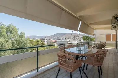 a balcony with a table and chairs on it at Voula's 2BR Escape Elegant and Stylish Living in Athens