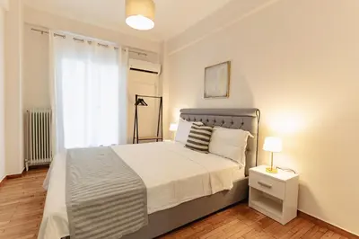 a bedroom with a large bed and a window at Athens downtown apartment 2bd-2ba in Athens
