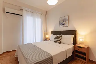 a bedroom with a large bed and two lamps at Athens downtown apartment 2bd-2ba in Athens