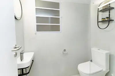 a white bathroom with a toilet and a sink at Athens downtown apartment 2bd-2ba in Athens