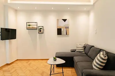 a living room with a couch and a tv at Athens downtown apartment 2bd-2ba in Athens
