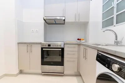 a kitchen with white cabinets and a stainless steel oven at Athens downtown apartment 2bd-2ba in Athens