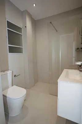 a white bathroom with a toilet and a sink at Athens downtown apartment 2bd-2ba in Athens