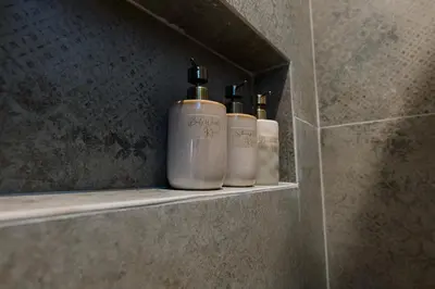 three bottles of soap sitting on a shelf in a bathroom at MrK Rooftop 1 in Athens