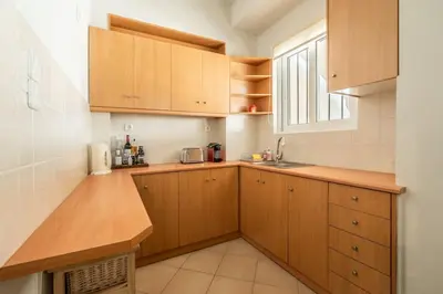 a kitchen with wooden cabinets and a sink and a window at Family 2BR Apt By National Archaeological Museum in Athens
