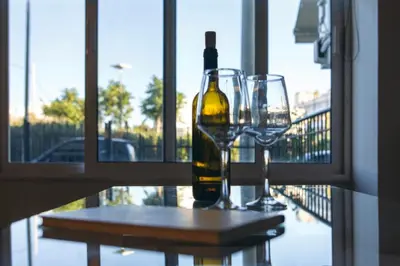 a bottle of wine and two glasses on a table at Astak in Piraeus