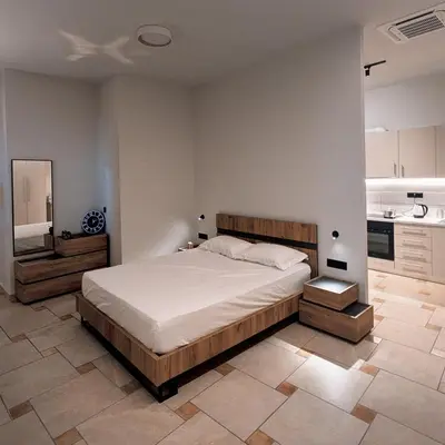 a bedroom with a large bed and a kitchen at Astak in Piraeus