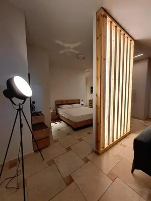 a bedroom with a bed and a light on a tripod at Astak in Piraeus