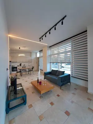 a living room with a blue couch and a table at Astak 2 in Piraeus