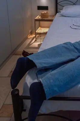a person wearing blue socks sitting on a bed at Astak 2 in Piraeus