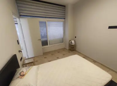 a bedroom with a large bed in a room with a window at Astak 2 in Piraeus