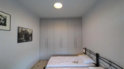 a bedroom with a bed and a white wall at Astak 2 in Piraeus