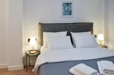 a bedroom with a large bed with white sheets and pillows at Cozy apartment in Pireus in Piraeus