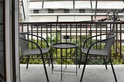 two chairs and a table on a balcony at Cozy apartment in Pireus in Piraeus