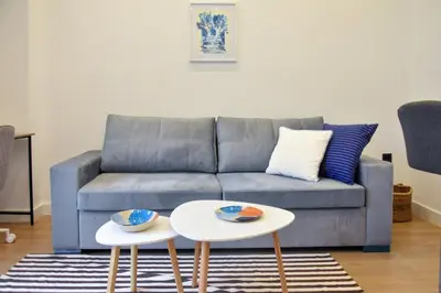 a living room with a couch and two tables at Cozy apartment in Pireus in Piraeus