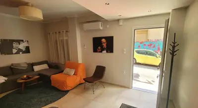 a living room with a couch and a chair at 'Home Downtown' in Athens