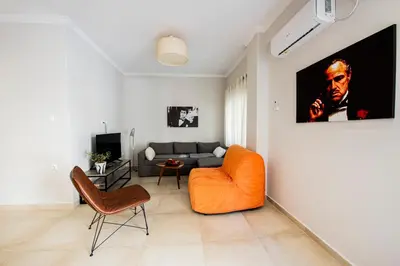a living room with an orange chair and a couch at 'Home Downtown' in Athens