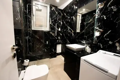 a black and white bathroom with a toilet and a sink at 'Home Downtown' in Athens