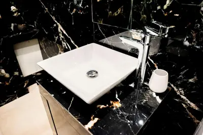 a white sink in a black marble bathroom at 'Home Downtown' in Athens
