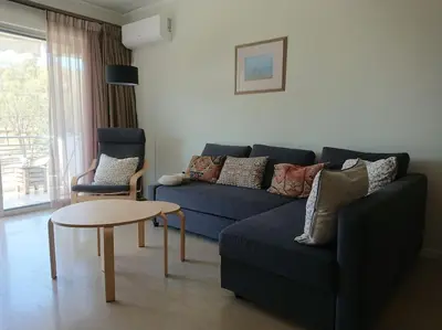 a living room with a blue couch and a table at Athens Riviera Beach Retreat in Athens