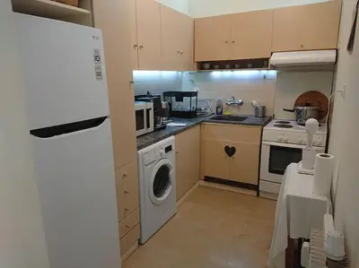 a kitchen with a washing machine and a washer at Athens Riviera Beach Retreat in Athens