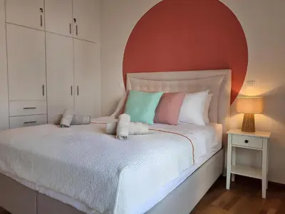a bedroom with a white bed with an orange headboard at Athens Stylish Renovated 62sqm Apartment for Families & Couples with Balcony in Quiet Area near City Center in Athens