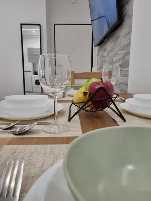 a table with plates and wine glasses on it at Athens Stylish Renovated 62sqm Apartment for Families & Couples with Balcony in Quiet Area near City Center in Athens