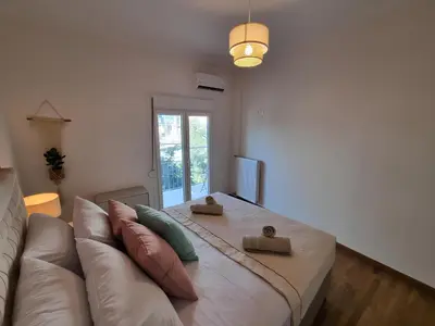 a living room with a large white bed and a couch at Athens Stylish Renovated 62sqm Apartment for Families & Couples with Balcony in Quiet Area near City Center in Athens