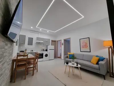 a living room with a couch and a table at Athens Stylish Renovated 62sqm Apartment for Families & Couples with Balcony in Quiet Area near City Center in Athens