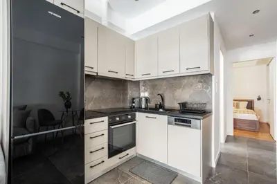 a kitchen with white cabinets and a sink at Glimmer 2-Bedroom Apartment in Athens in Athens