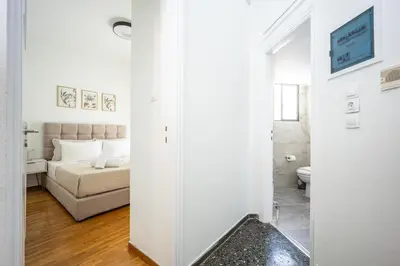 a white living room with a couch and a mirror at Upper House in Athens