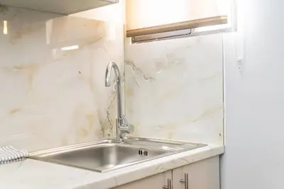 a stainless steel sink in a white kitchen at Upper House in Athens