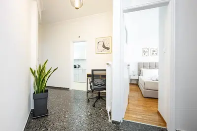 a white living room with a table and a couch at Upper House in Athens