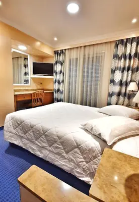 a hotel room with a large bed and a desk at Noufara in Piraeus