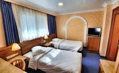 a hotel room with two beds and a television at Noufara in Piraeus