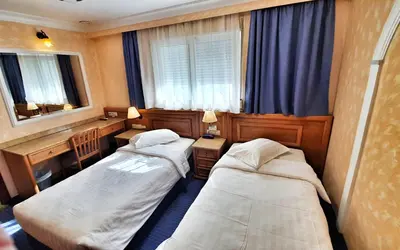 two beds in a small room with a window at Noufara in Piraeus