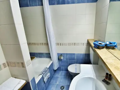 a blue and white bathroom with a toilet and a sink at Noufara in Piraeus