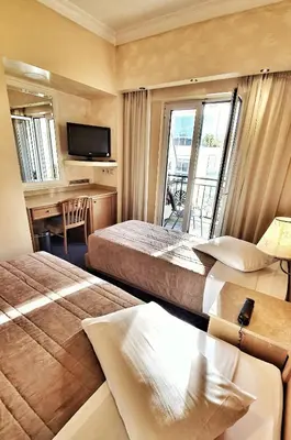 a hotel room with two beds and a balcony at Noufara in Piraeus