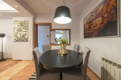 a dining room with a black table and chairs at Shoreline Athens Riviera in Athens