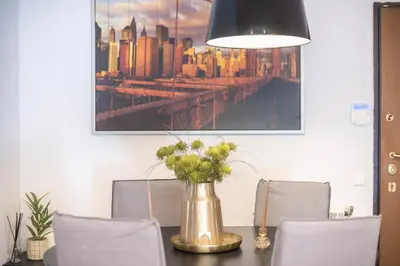 a dining room table with a vase of flowers at Shoreline Athens Riviera in Athens