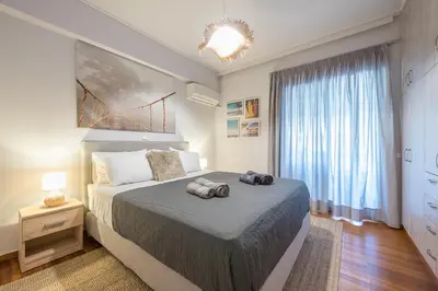 a bedroom with a bed and a large window at Shoreline Athens Riviera in Athens
