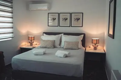 a bedroom with a bed with two pillows and two lamps at Athens Horizon in Athens