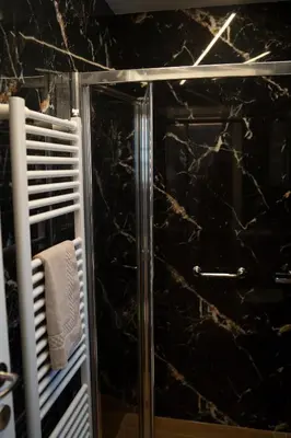 a bathroom with a shower with black marble at Athens Horizon in Athens