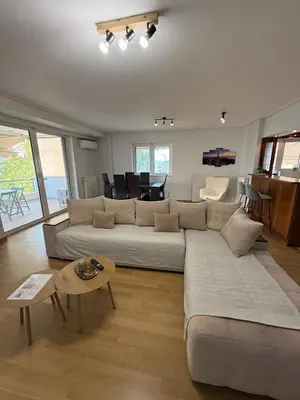 a living room with a large couch and a table at Elliniko Luxury Apartment in Athens