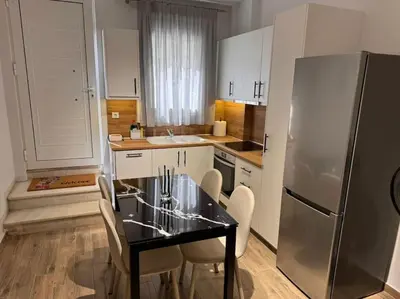 a kitchen with a table and chairs and a refrigerator at My house apartment jp in Athens